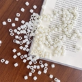 Macro shot of white square acrylic beads on a wooden table for DIY jewelry making crafts - Approx. 150 Pcs (5mm, 3mm Hole) / Off-white