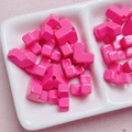 Nahaufnahme von leuchtend rosa Acrylperlen mit diagonalen Löchern in einer weißen Schale - 12mm (2.6mm Loch) / Fuchsia