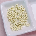 Close-up of small cream yellow alloy flower beads for DIY jewelry and phone chains - 6.3mm / Light Yellow