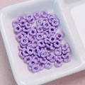 Close-up of light purple wavy flower-shaped spacer beads for DIY jewelry making - 6.3mm / Purple