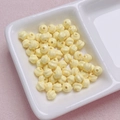 Detailed view of creamy yellow acrylic twist beads with wave texture for DIY jewelry - 6mm / Light Yellow