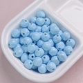 Macro detail of 10mm light blue acrylic beads in a ceramic tray for DIY jewelry making - 10mm / Blue