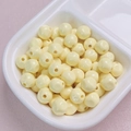 Macro detail of 10mm glossy cream yellow acrylic beads for DIY jewelry making and crafts - 10mm / Light Yellow
