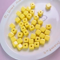 Close-up of 12mm yellow acrylic cube beads with smooth ceramic texture for DIY crafts - 12mm / Yellow