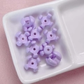 Detalle macro de cuentas de estrella acrílicas lavanda para joyas DIY y accesorios - 10x15mm / Púrpura