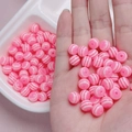 Dettaglio macro di perle rotonde a strisce rosa e bianche per creazione di gioielli DIY - Rosa Brillante Solido