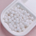 Gros plan de perles en résine à rayures blanches pour bijoux DIY dans un plat en céramique - 10mm (Vendu à la Pièce) / Blanc Translucide
