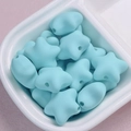 Dettaglio delle perle a stella in acrilico azzurro con finitura opaca in piatto bianco - Ciano