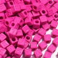 Vue macro des perles carrées en acrylique fuchsia avec lettres pour bijoux DIY - 12mm / Rouge Rose Vif