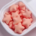 Macro detail of macaron star acrylic beads with a smooth matte cream finish for DIY crafts - Orange