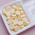 Macro shot of yellow acrylic spiral beads for DIY jewelry making in a white ceramic tray - Size Approx 10x12mm Hole Approx 2mm / Light Yellow
