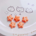 Nahaufnahme orangefarbener Acryl-Sternperlen mit Spiralmustern für DIY-Schmuck - Orange