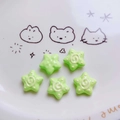 Detail of five green acrylic star beads with spiral patterns for DIY jewelry crafts - Green