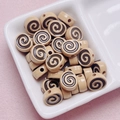 Detailed macro of acrylic Swiss roll beads with spiral patterns for DIY jewelry making - Size Approx 10x12mm Hole Approx 2mm / Light Coffee