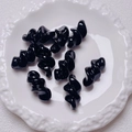 Macro shot of 9 black spiral acrylic beads on a white vintage porcelain tray for DIY crafts - 27.5x14mm / Black