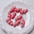 Detail of pink spiral acrylic beads on a white textured ceramic plate for DIY jewelry making - 27.5x14mm / Pink