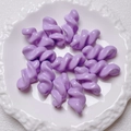 Top view of lavender acrylic twisted spiral beads arranged on a white floral ceramic plate - 27.5x14mm / Purple