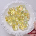 Detail of cute chubby cloud beads with shimmering UV rainbow coating in a ceramic dish - 22x32mm (Sold by Piece) / Yellow