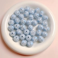 Macro detail of 16mm glitter acrylic round beads with blue heart pattern for DIY crafts - 16mm / Blue