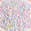 Perles en acrylique dégradé aurore colorées dans un bol pour création bijoux - Couleurs Mélangées