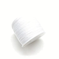 White elastic beading thread on a spool for DIY jewelry making and acrylic bead bracelets - White