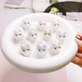 Macro detail of 3D pig-shaped cartoon beads with a vibrant UV pearl rainbow finish - Iridescent White Pig