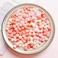 Close-up of matte macaron acrylic beads in pastel pink and beige for DIY jewelry crafts - Pink Series
