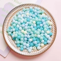 Macro detail of matte pastel acrylic beads in a ceramic tray for DIY jewelry making - Pastel Colors