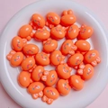 Close-up of 20mm orange acrylic bunny beads for DIY jewelry making in a ceramic dish - 20mm (2mm Aperture) / Glossy Orange