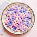 Close-up of matte 6mm colorful acrylic round beads in a dish for DIY craft jewelry - Pink and Purple Series