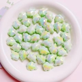 Macro-opname van lichtgroene iriserende wolkkralen voor DIY-sieraden in een witte kom - Klein 14x18.5mm / Groen