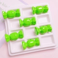Makroaufnahme grüner Harzperlen in Bonbonform für DIY-Schmuck in einer weißen Schale - 15x31mm (1 Stück) / Obstgrün