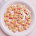 Detail of macaron bow beads in colorful acrylic for DIY jewelry and hair accessories - 20x17mm / Orange
