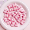 Vista dettagliata di perline a fiocco rosa macaron con finitura perlata per gioielli fai da te - 20x17mm / rosa acceso