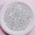 Détail de perles rondes blanches irisées avec revêtement UV pour la création de bijoux - Vert clair