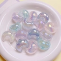 Macro shot of iridescent crescent moon beads with sparkling glitter inside a white bowl - 22x25mm / Random Mixed Colors