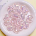 Nahaufnahme von glitzernden rosa Harzmond-Perlen für DIY-Schmuck in einer Keramikschale - Hellrosa