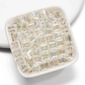 Makroansicht von transparenten AB-beschichteten Acryl-Wuerfelperlen in einer weissen Schale - 8mm / Weiß