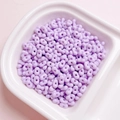 Polished purple acrylic peanut beads for DIY jewelry making in a white ceramic dish - 200 Pieces/Pack (Approx. 4x6mm) / Glossy Purple
