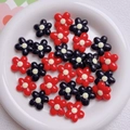 Close-up of 20mm acrylic flower beads in red and black with white centers for DIY - Mixed Red
