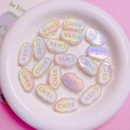 Macro shot of iridescent cloud-shaped acrylic beads with 3D Cute lettering for DIY crafts - Luminous White