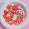 Macro detail of iridescent orange acrylic beads with raised cute letters for DIY jewelry - Glow in the Dark Orange