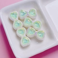 Close-up of bow-shaped butterfly beads with green aurora zircon crystals for DIY crafts - Green