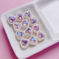 Macro shot of 8 heart-shaped zircon bow beads in pink and iridescent white finishes - Transparent Pink