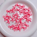 Macro view of bright pink hollow metal bow beads for DIY jewelry and phone chains - Rose Red