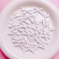 Detailopname van glanzende witte strikbedeltjes op roze achtergrond voor DIY-sieraden - 16.5x27mm (H3-Gestipte Strik) / Wit