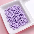 Close-up of polished purple alloy donut spacer beads for DIY jewelry making - Purple
