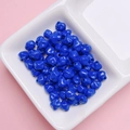 Vista macro de cuentas carambola azul oscuro de 7mm para joyería DIY en un plato de cerámica - 7mm / Azul Zafiro