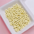 Creamy yellow donut-shaped spacer beads in a white tray for DIY jewelry making - Light Yellow