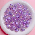 Dettaglio di perline a forma di maiale in resina viola glitterata in un piatto bianco - 16mm / Viola
